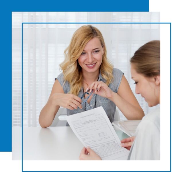 woman looks at job application while another looks at her across table