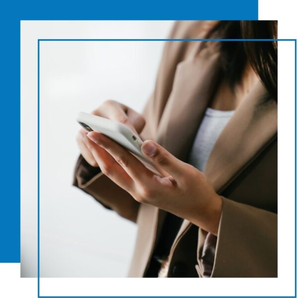 woman holds phone in one hand and scrolls with other