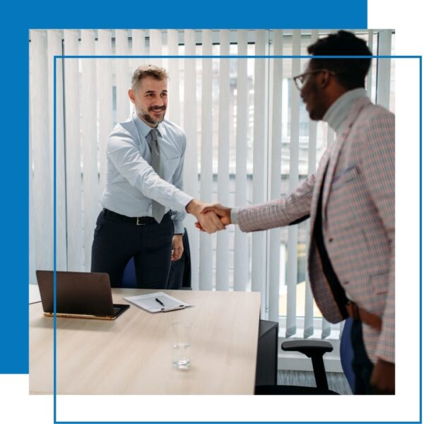 men shake hands in office