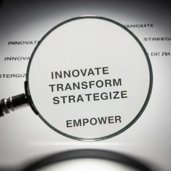 A magnifying glass hovering over the words Innovate, Transform, Strategize, Empower